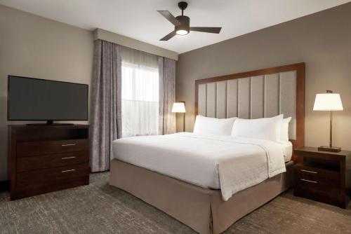 a bedroom with a bed and a flat screen tv at Homewood Suites Fort Wayne in Fort Wayne