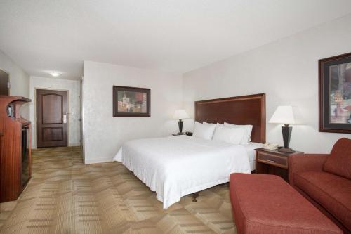 um quarto de hotel com uma cama e um sofá em Hampton Inn Siloam Springs em Siloam Springs