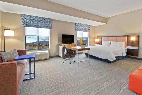 スポケーン・バレーにあるHampton Inn & Suites Spokane Valleyのベッドとデスクが備わるホテルルームです。