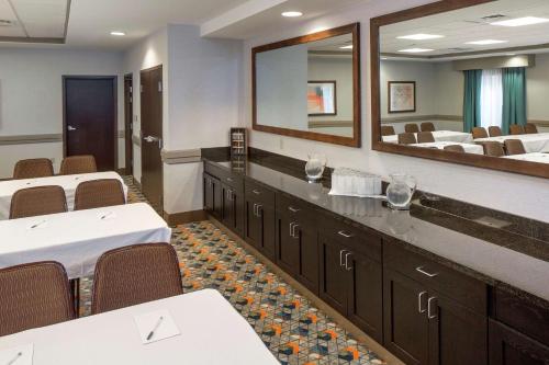 a conference room with tables and chairs and a mirror at Hampton Inn & Suites Spokane Valley in Spokane Valley