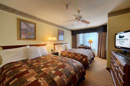ロングビューにあるHomewood Suites by Hilton- Longviewのベッド2台、薄型テレビが備わるホテルルームです。
