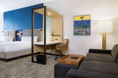 トピカにあるSpringHill Suites by Marriott Topeka Southwestのベッドとデスクが備わるホテルルームです。