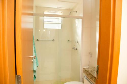 ein Bad mit einer Glasdusche und einem WC in der Unterkunft Conforto & tranquilidade in Rio das Ostras