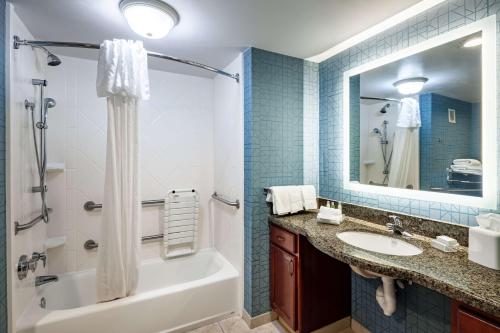 a bathroom with a tub and a sink and a mirror at Homewood Suites by Hilton Gainesville in Gainesville