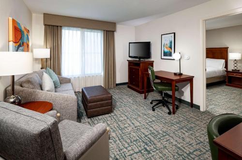 a hotel room with a bed and a desk with a computer at Homewood Suites by Hilton Gainesville in Gainesville
