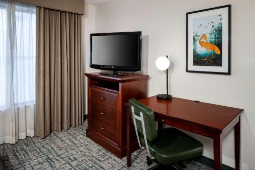 a hotel room with a desk with a television and a deskablish at Homewood Suites by Hilton Gainesville in Gainesville