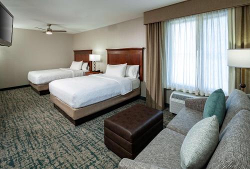 a hotel room with two beds and a couch at Homewood Suites by Hilton Gainesville in Gainesville