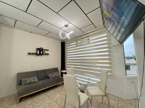 ein Wohnzimmer mit einem Sofa und einem Tisch in der Unterkunft Moderno, grande, amplia vista, parqueo in Machala