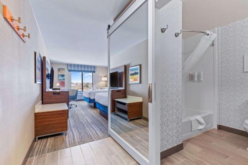 a bathroom with a shower and a bedroom at Hampton Inn & Suites Greeley in Greeley