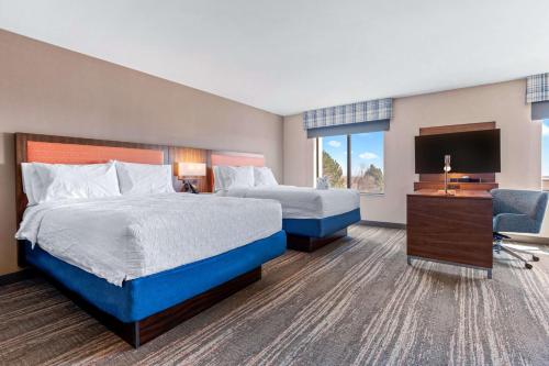 a hotel room with two beds and a television at Hampton Inn & Suites Greeley in Greeley