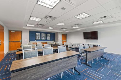 a conference room with tables and chairs and a tv at Hampton Inn & Suites Greeley in Greeley