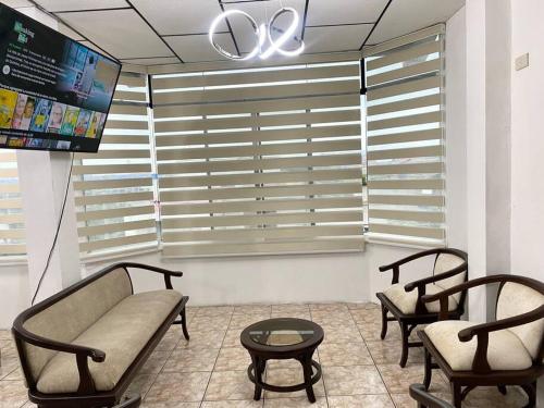 a waiting room with two chairs and a tv at Moderno, grande, amplia vista, parqueo in Machala