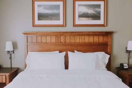 a bedroom with a white bed with two pictures on the wall at Hampton Inn & Suites Green River in Green River