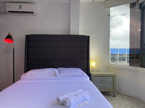 a bedroom with a bed with two towels on it at Moderno, grande, amplia vista, parqueo in Machala