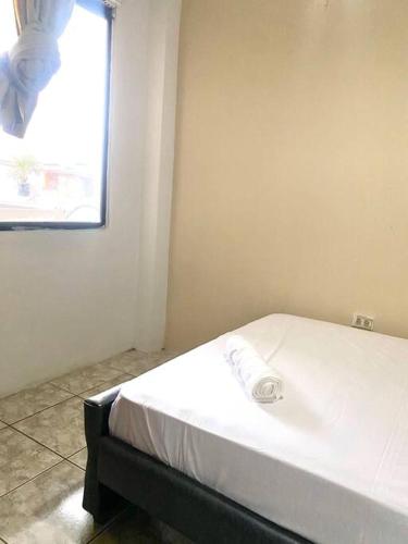 a bedroom with a white bed with a window at Moderno, grande, amplia vista, parqueo in Machala