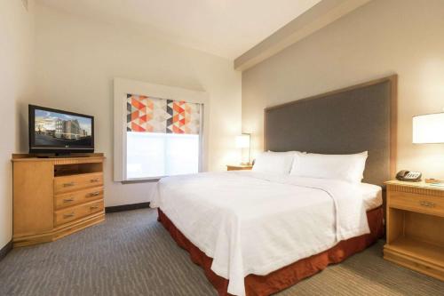 a hotel room with a large bed and a television at Homewood Suites by Hilton at Carolina Point - Greenville in Greenville