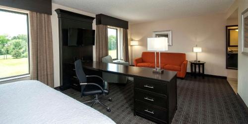a hotel room with a desk and a bedroom at Hampton Inn & Suites Seneca-Clemson Area in Seneca