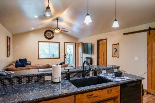 a kitchen with a sink and a living room at Pinetree Lodge: Hot Tub Fire Pit in Athol