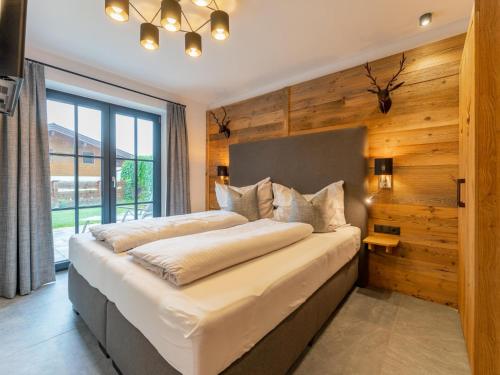 a bedroom with a large bed with a wooden wall at Tauernsuites Uttendorf by Mimi in Uttendorf
