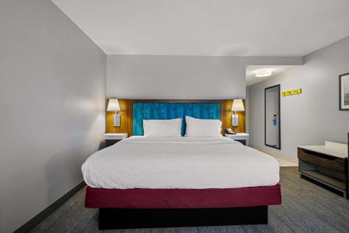 a hotel room with a large bed and a couch at Hampton Inn & Suites Schererville in Schererville