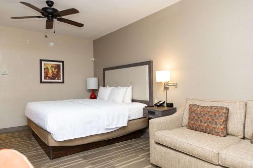 a hotel room with a bed and a couch at Hampton Inn Hammond in Hammond