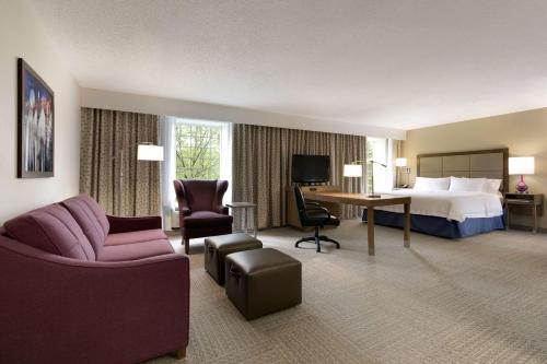 a large hotel room with a bed and a desk at Hampton Inn & Suites Hershey in Hershey