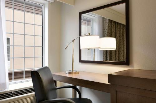 a office with a desk and a mirror and a chair at Hampton Inn & Suites Hershey in Hershey