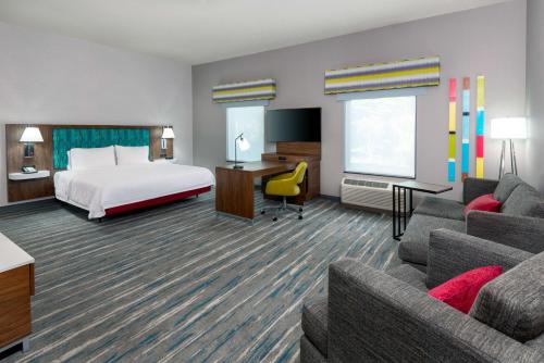 a hotel room with a bed and a couch at Hampton Inn and Suites Hartford/Farmington in Farmington