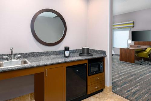 ein Bad mit einem Waschbecken und einem Spiegel in der Unterkunft Hampton Inn and Suites Hartford/Farmington in Farmington