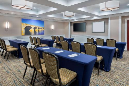 a conference room with tables and chairs and a screen at Hampton Inn and Suites Hartford/Farmington in Farmington