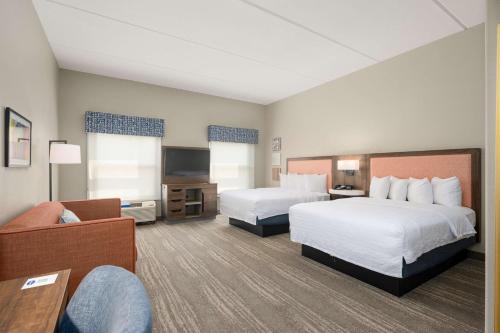 a hotel room with two beds and a couch at Hampton Inn & Suites Harlingen in Harlingen