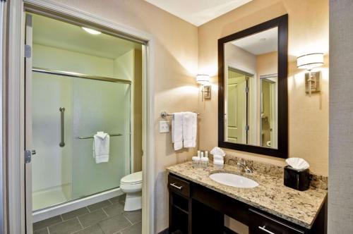 a bathroom with a sink and a toilet and a mirror at Homewood Suites by Hilton Hartford / Southington CT in Southington