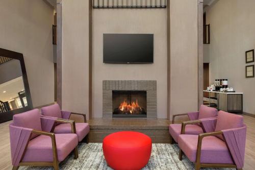 a living room with a fireplace and a tv at Hampton Inn & Suites Houston-Cypress Station in Westfield