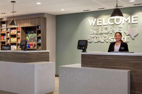 a woman standing at a welcomeelcome to the lone starbucks counter at Hampton Inn & Suites Houston-Cypress Station in Westfield