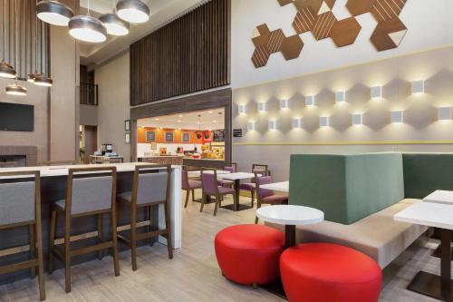 a restaurant with tables and chairs and a bar at Hampton Inn & Suites Houston-Cypress Station in Westfield