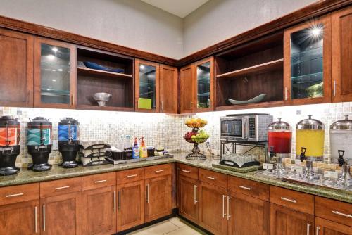 a kitchen with wooden cabinets and a counter top at Homewood Suites by Hilton Houston Near the Galleria in Houston