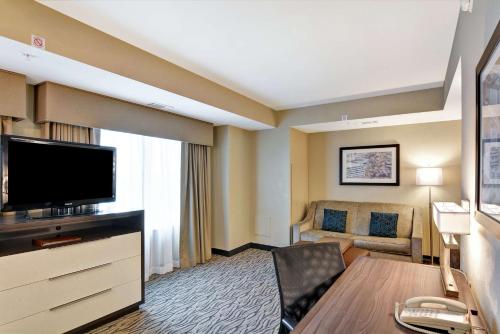 a hotel room with a television and a couch at Homewood Suites by Hilton Houston Near the Galleria in Houston