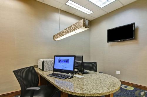 a desk with a computer on a table with chairs at Homewood Suites by Hilton Houston Near the Galleria in Houston