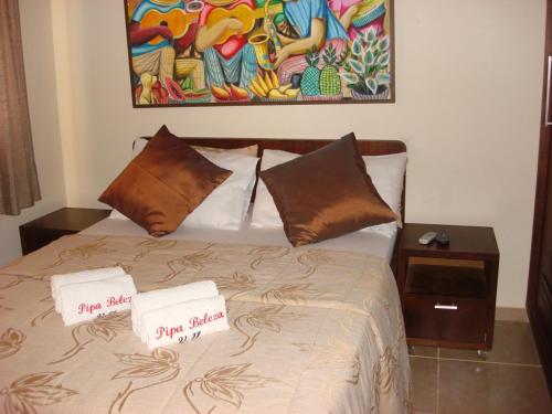 a bedroom with a bed with two signs on it at Suites Pipa Beleza Spa Resort in Pipa