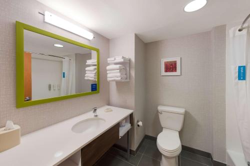 a bathroom with a toilet and a sink and a mirror at Hampton Inn Nanuet in Nanuet
