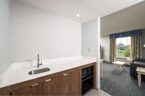 a kitchen with a sink and a living room at Hampton Inn & Suites - Cape Cod / West Yarmouth in West Yarmouth