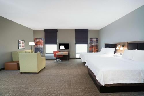 a hotel room with two beds and a desk at Hampton Inn Huntsville-Madison in Madison