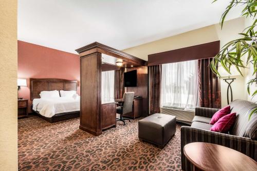 een hotelkamer met een bed en een bank bij Hampton Inn Derby-Wichita Southeast in Derby