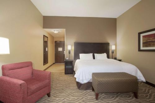 Habitación de hotel con cama y silla en Hampton Inn & Suites I-35/Mulvane, en Mulvane