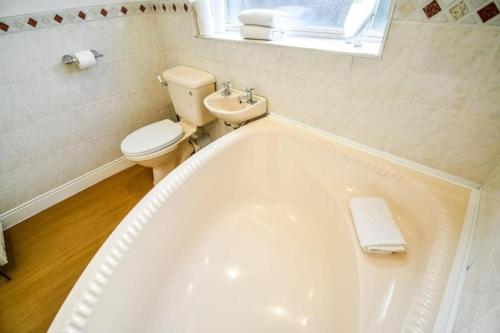 y baño con bañera, aseo y lavamanos. en Buckingham House - 4 Bed House en Redcar