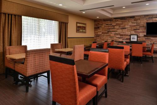 a restaurant with tables and chairs and a television at Hampton Inn Idaho Falls / Airport in Idaho Falls