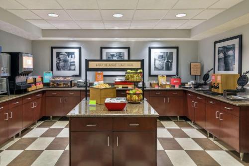 a large kitchen with wooden cabinets and a checkered floor at Hampton Inn by Hilton Indianapolis-South in Southport