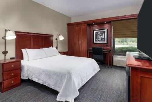 a hotel room with a bed and a desk at Hampton Inn Indianapolis-South in Southport