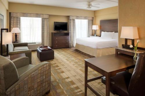a hotel room with a bed and a living room at Homewood Suites by Hilton Coralville - Iowa River Landing in Coralville