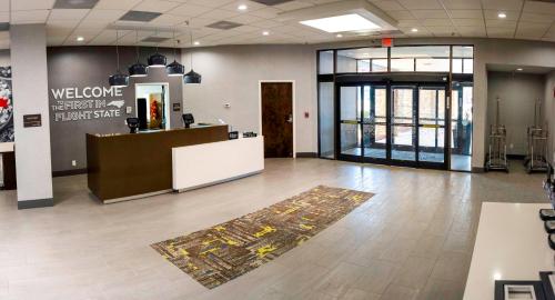 a lobby with a welcome sign on the wall and a counter at Hampton Inn Kinston in Kinston